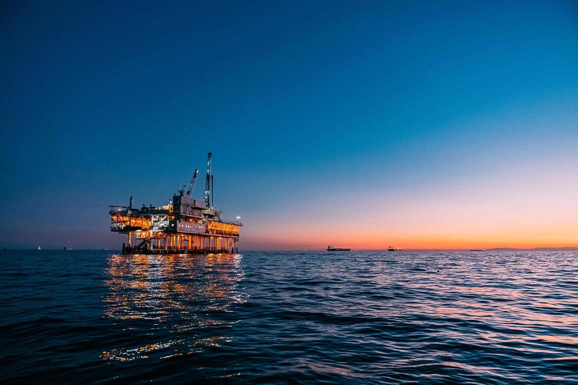 Offshore Oil Rig Reflecting off the Pacific Ocean at Sunset near Huntington Beach, California with Copy Space